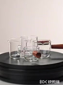 Copo de medição de café expresso com cabo de madeira.